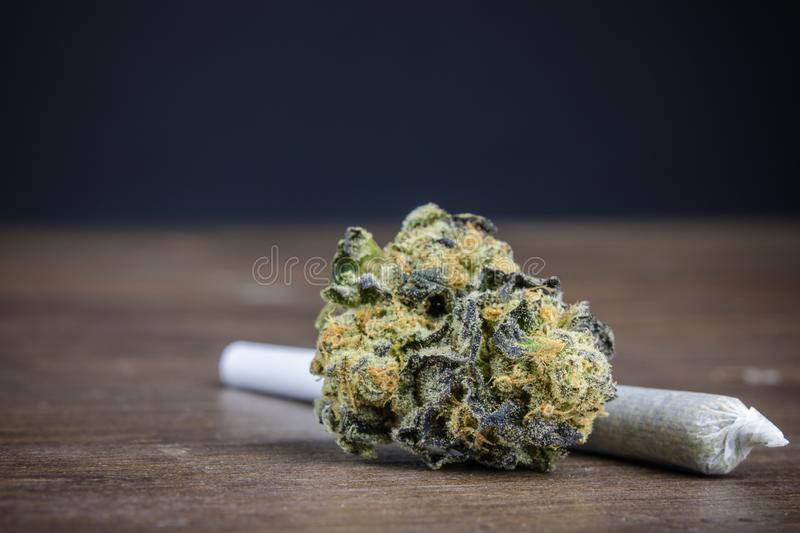 high-quality-potent-marijuana-bud-weed-joint-wood-table-dark-background-selective-focus-macro-close-up-close-up-144145858.jpg